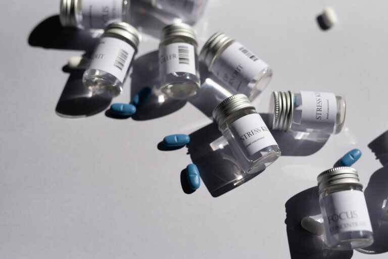 Close-up of medicine bottles and blue pills on a white background, emphasizing healthcare.