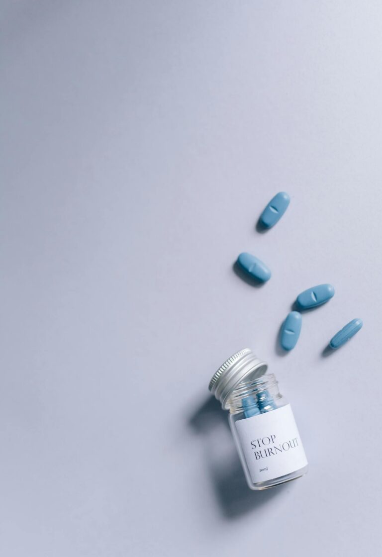 Creative conceptual photo of pills labeled 'Stop Burnout' on a gray surface, top view.